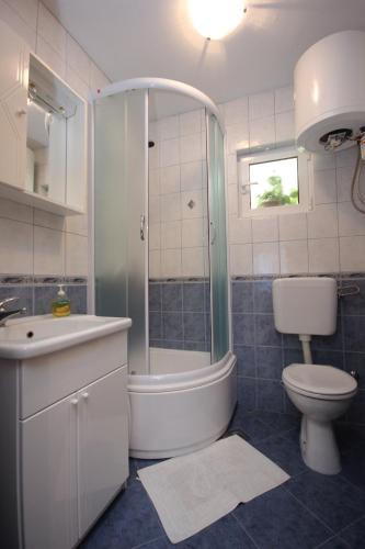 a bathroom with a tub and a toilet and a sink at Apartments by the sea Vis - 2459 in Vis