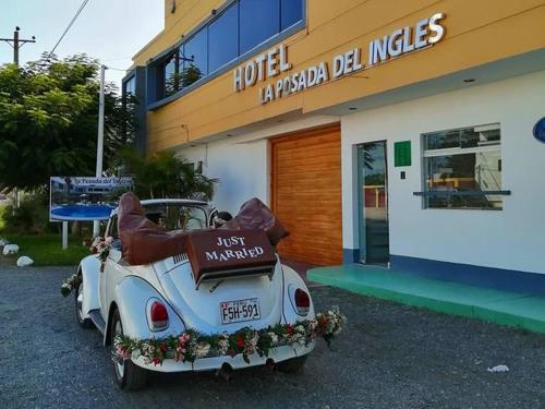 an old car parked in front of a building at Hotel La Posada Del Ingles in Chiclayo