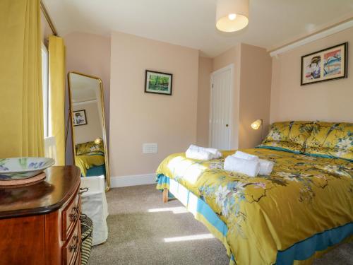 1 dormitorio con cama, tocador y espejo en 7 The Green, en Lichfield