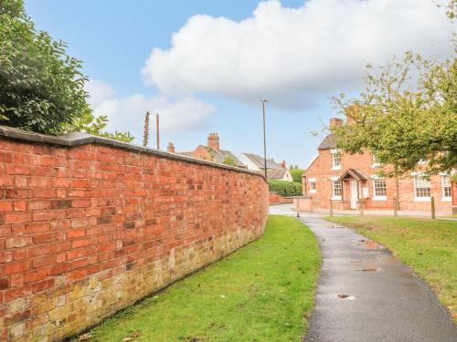 a brick wall in front of a house at 7 The Green in Lichfield