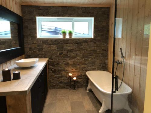 a bathroom with a tub and a sink and a toilet at Holiday home Skare in Skare