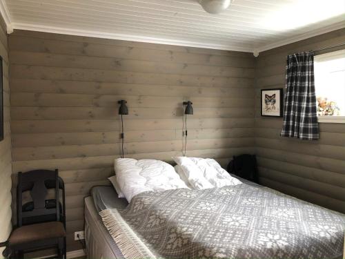 1 dormitorio con 1 cama en una habitación con paredes de madera en Holiday home Skare, en Skare