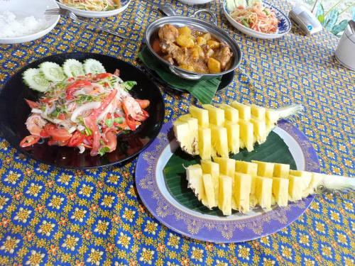 una mesa con dos platos de comida. en Wassana Camp & Khai Jungle Experience Centour, en Ban Kraison