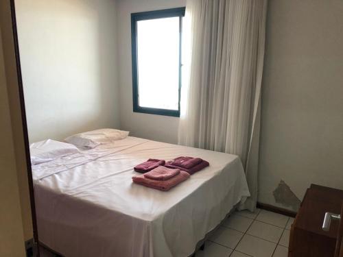 um quarto com uma cama com duas toalhas em Amplo apartamento em Guarapari com vistas pro mar em Guarapari