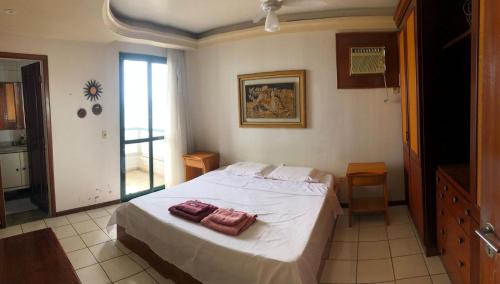 a bedroom with a bed with two towels on it at Amplo apartamento em Guarapari com vistas pro mar in Guarapari
