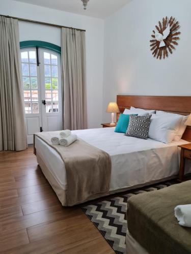 - une chambre avec un grand lit et une fenêtre dans l'établissement Pousada Candelabro, à Tiradentes