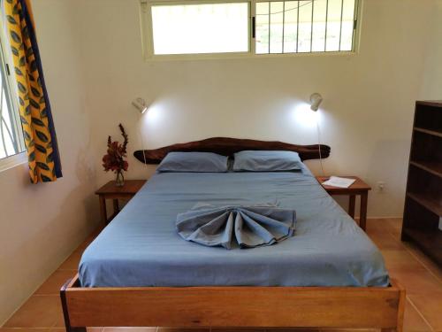 una camera con un letto e una coperta blu di Mira Olas Cabins a Pavones