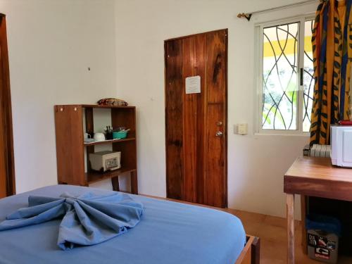 a bedroom with a blue bed and a wooden door at Mira Olas Cabins in Pavones