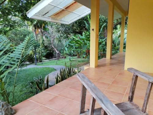 una veranda con 2 sedie in legno e un soffitto bianco di Mira Olas Cabins a Pavones