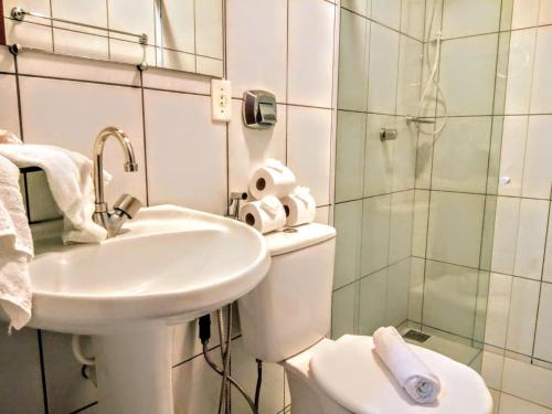 a bathroom with a sink and a toilet and a shower at Casa de Temporada no Centro de Pedra Azul in Pedra Azul