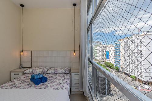 1 dormitorio con cama y ventana grande en Modern Apartment perto 1 block Copacabana Beach best beach - Rio Janeiro en Río de Janeiro