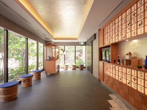 a hallway in a building with windows and stools at MIMARU Osaka Shinsaibashi East in Osaka