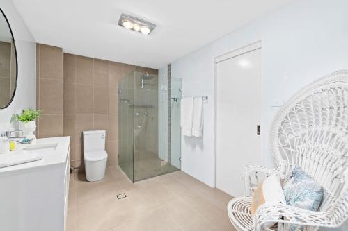 une salle de bain avec toilettes et douche en verre dans l'établissement Waterfront at Sunset Boulevard 26 Sunset Boulevard, à Soldiers Point