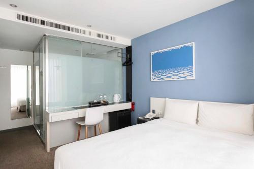 a bedroom with a white bed and a desk at CityInn Hotel Taipei Station Branch III in Taipei