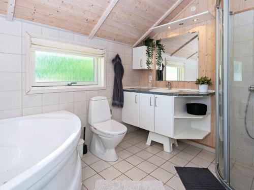 uma casa de banho com uma banheira, um WC e um lavatório. em Holiday home Toftlund XLV em Toftlund