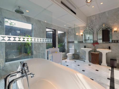 a large bathroom with a tub and two sinks at Kaba Kaba Estate in Tabanan