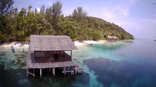 uma ilha com uma casa no meio da água em Meos Ambower Homestay Raja Ampat em Fam