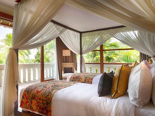 a bedroom with a bed with a canopy at Kaba Kaba Estate in Tabanan