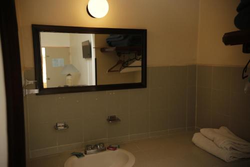 a bathroom with a sink and a mirror at Hotel Posada Santa Fe Sabinas in Sabinas