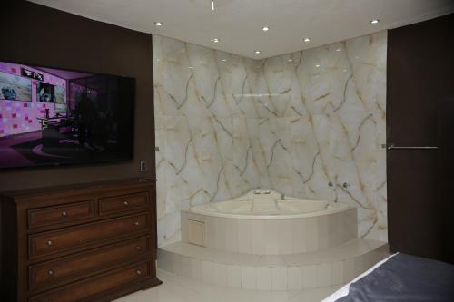 a large bathroom with a tub and a tv at Hotel Posada Santa Fe Sabinas in Sabinas