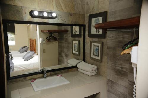 a bathroom with a sink and a mirror at Hotel Posada Santa Fe Sabinas in Sabinas