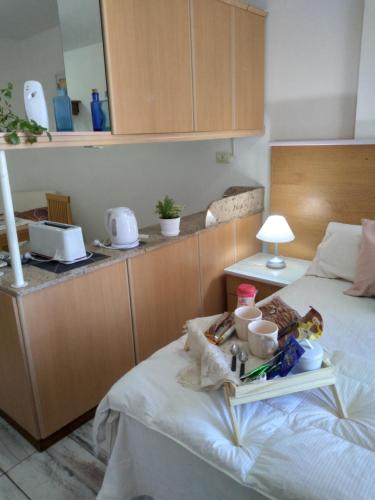 una camera con un letto e un vassoio di cibo sopra di Arcángeles a Rosario