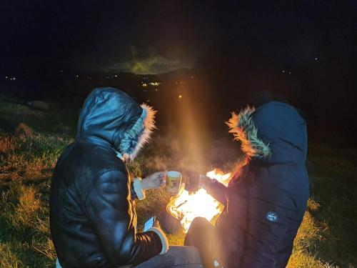two people sitting around a fire at night at Cabañas Casa Campo Guatavita in Guatavita