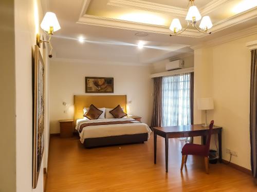 a bedroom with a bed and a table and a desk at Flamingo Hotel By The Lake, Kuala Lumpur in Kuala Lumpur