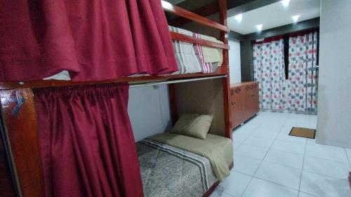 a bedroom with two bunk beds with red curtains at Casa Sucre Hostel Ayacucho in Ayacucho