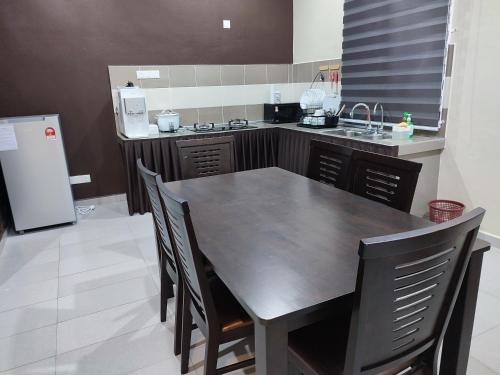 a kitchen with a table and chairs and a refrigerator at Villa Tamu Dr Din - Pool OR Soopa Doopa in Rantau Panjang