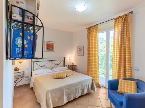 een slaapkamer met een bed, een stoel en een raam bij Romantic cottage in San Feliciano with garden in San Feliciano