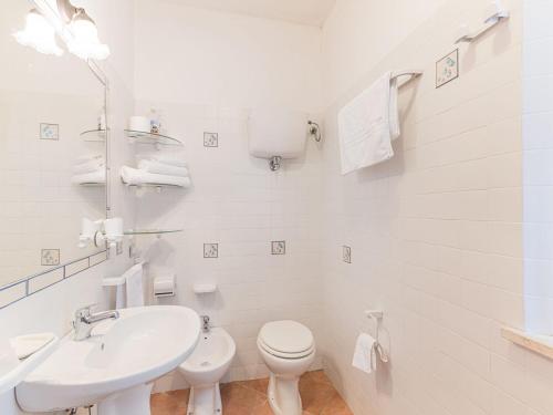 een witte badkamer met een wastafel en een toilet bij Romantic cottage in San Feliciano with garden in San Feliciano