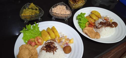 tres platos blancos de comida en una mesa en Queens Airport Residence en Negombo