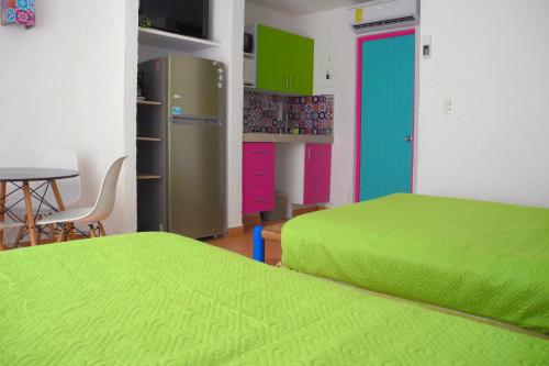 a room with two beds and a desk and a table at Beach, fun & relax at the Hotel Zone in Cancun in Cancún