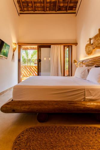a large bed in a bedroom with a window at VillaMag in Jericoacoara