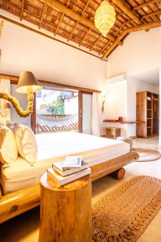 a bedroom with a bed and a table with books at VillaMag in Jericoacoara