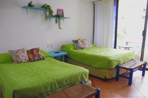 Habitación con 2 camas con sábanas verdes en Beach, fun & relax at the Hotel Zone in Cancun en Cancún
