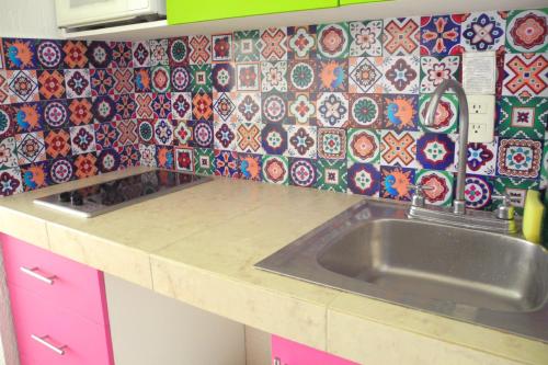 cocina con fregadero y pared de azulejos en Beach, fun & relax at the Hotel Zone in Cancun en Cancún