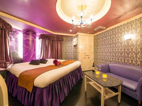 神戶的住宿－圖庫情趣酒店（僅限成人），紫色的客房配有一张床和一张沙发