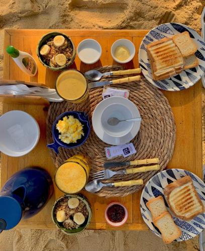 ein Tisch mit Tellern voller Frühstücksspeisen darauf in der Unterkunft Pousada Belas Águas in Praia de Araçatiba