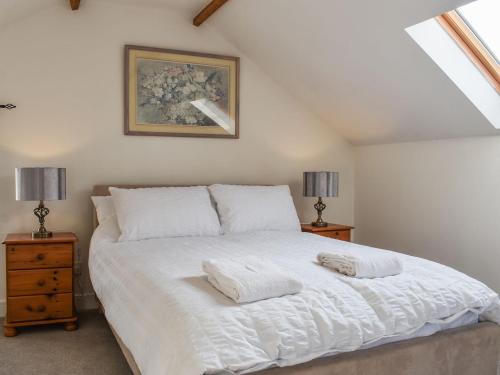 um quarto com uma grande cama branca e 2 candeeiros em Sunset View-uk40639 em Stainton