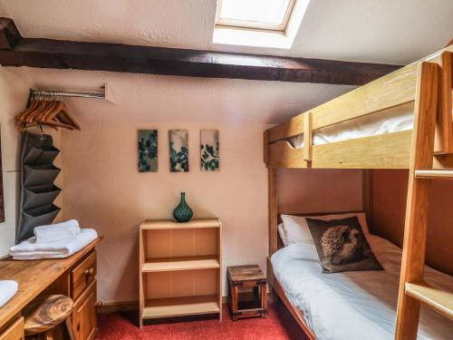 a bedroom with two bunk beds and a desk at The Cottage at Graysondale Farm in Cockermouth