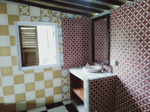 a small bathroom with a sink and a window at D'Ume Bendoel Homestay in Jatiluwih