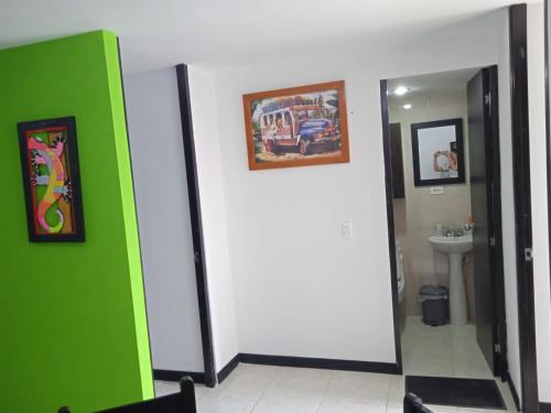 a bathroom with a green and white wall and a sink at Guaduales del Café 211B in Montenegro