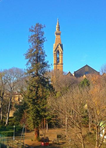 a clock tower in the background with a tree in the foreground at Residenza Marchesi Pontenani in Florence