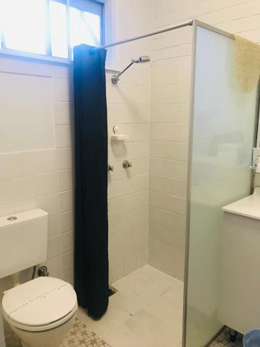 a bathroom with a toilet and a glass shower at Kaputar Motel in Narrabri