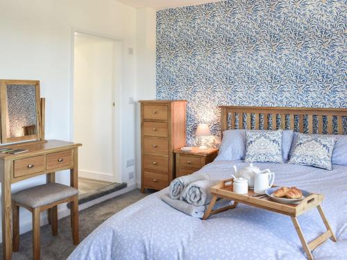 a bedroom with a bed and a table with a tray of food at Bryn Y Felin in Dyffryn