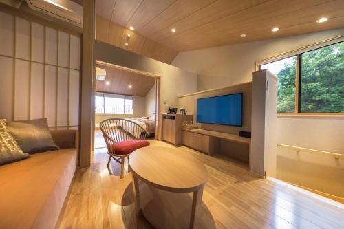 a living room with a couch and a table and a tv at 八海 木花館 in Oshino