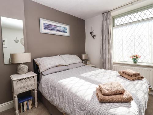um quarto com uma cama grande e uma janela em Woodman Cottage em Skipton