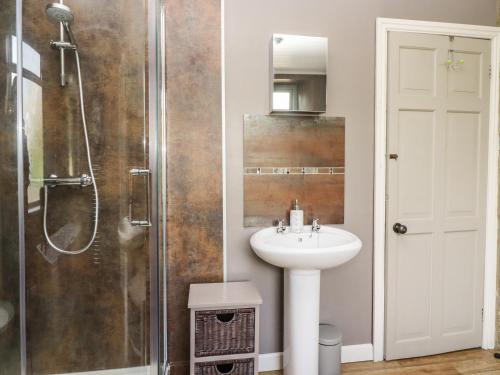 ein Badezimmer mit Waschbecken und Dusche in der Unterkunft Woodman Cottage in Skipton